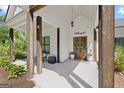 Inviting front porch with wood columns, a 'welcome' sign, double wood doors, and tasteful decor for a warm ambiance at 11807 Alcovy Rd, Covington, GA 30014