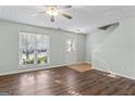Inviting living room with hardwood floors, large window, ceiling fan and neutral paint at 11439 South Grove Dr, Hampton, GA 30228