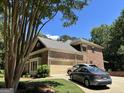 Side view of a brick home featuring an attached garage and well-manicured lawn at 245 River Laurel Way, Woodstock, GA 30188