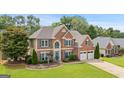 Traditional two-story brick home with manicured lawn, charming curb appeal, and an attached garage at 960 Pebblestone Ct, Alpharetta, GA 30009