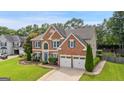 Stately brick home with an attached two-car garage and lush, green landscaping at 960 Pebblestone Ct, Alpharetta, GA 30009