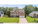 Beautiful brick home boasts a well-kept lawn, blue shutters, and a two-car garage at 960 Pebblestone Ct, Alpharetta, GA 30009