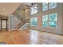 Bright and airy living room with hardwood floors, tall windows, and a staircase at 375 Foster Dr, Mcdonough, GA 30253
