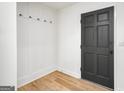 Bright entryway with built-in storage, hooks, wood-look flooring, and a black front door at 7455 Dover Ct, Riverdale, GA 30274
