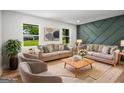 Staged living room with neutral furniture, modern accent wall, and natural light at 7455 Dover Ct, Riverdale, GA 30274
