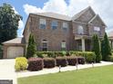 A spacious home with brick and stone accents is complemented by lush landscaping and a convenient two-car garage at 1869 Schofield Dr, Hampton, GA 30228