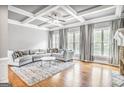 Bright living room with hardwood floors, coffered ceiling, fireplace, and neutral decor at 4818 Moon Hollow Ct, Buford, GA 30519