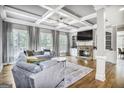 Spacious living room with coffered ceilings, hardwood floors, and a stone fireplace at 4818 Moon Hollow Ct, Buford, GA 30519