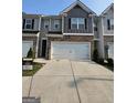 Townhome featuring a two-car garage and a modern exterior design with neutral color palette and brick accents at 190 Hampton Cir, Mcdonough, GA 30253