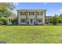 Two-story white home with brown shutters, lush landscaping, and a vibrant blue front door at 75 Auburn Rd, Auburn, GA 30011