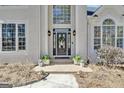 Close up of front door with brick walkway and potted plants on either side at 407 Blue Smoke Trl, Peachtree City, GA 30269