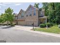 Attractive two-story townhome boasts brick, siding details, a manicured lawn, and an attached two-car garage at 2333 White Oak Se Bnd, Smyrna, GA 30080