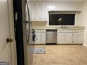 Bright kitchen features stainless steel appliances, white cabinets, and a sink beneath a large window at 1725 Sara Se Ct, Conyers, GA 30013