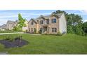 Spacious two-story home with brick facade, landscaped yard, and a welcoming front entrance on a grassy lawn at 361 Traditions Lane, Hampton, GA 30228