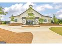 Community barn with white siding and black trim, features a gravel parking area and landscaping at 1676 Fuma Leaf Way # 305, Mcdonough, GA 30253
