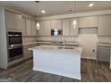 Modern kitchen features gray cabinets, granite countertops, stainless steel appliances, and an island at 1676 Fuma Leaf Way # 305, Mcdonough, GA 30253