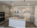 Modern kitchen features gray cabinets, granite countertops, stainless steel appliances, and an island at 1676 Fuma Leaf Way # 305, Mcdonough, GA 30253
