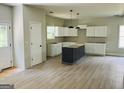 A kitchen featuring recessed lights, a black island, white cabinets, and hardwood flooring at 8035 Buffet, Riverdale, GA 30296