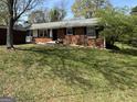 A traditional one-story brick home with a lush green lawn, black shutters, and a cozy front porch at 107 Woodhaven Dr, Stockbridge, GA 30281