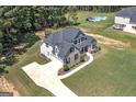 An aerial view of a luxurious home featuring a sprawling lawn, large driveway, and a backyard pool at 433 Wilson Dr, Mcdonough, GA 30252