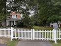Charming home with a white picket fence, surrounded by mature trees and a well-manicured lawn at 435 Jackson St, Locust Grove, GA 30248
