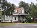 Charming two-story home with a covered porch and blooming hydrangeas set amidst lush greenery at 435 Jackson St, Locust Grove, GA 30248