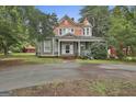 Charming two-story home with a welcoming front porch and a well-manicured lawn with beautiful accent turrets at 435 Jackson St, Locust Grove, GA 30248