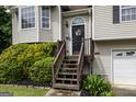 Inviting home entrance featuring a dark front door with decorative wreath and a wooden staircase at 639 Sheffield Ct, Villa Rica, GA 30180