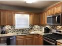 Modern kitchen boasting granite countertops, stainless steel appliances, and a stylish backsplash at 639 Sheffield Ct, Villa Rica, GA 30180