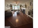 Spacious living room with hardwood floors, a cozy fireplace, and an abundance of natural light at 639 Sheffield Ct, Villa Rica, GA 30180