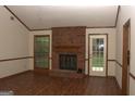 Spacious living room with a brick fireplace, wood trim, and a door to the backyard, and hardwood floors at 3857 Pointers Sw Way, Conyers, GA 30094