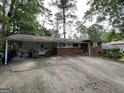 Ranch-style home with brick accents, covered parking, and mature trees providing ample shade at 1283 Bramble Ne Rd, Atlanta, GA 30329