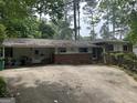 Ranch-style home with brick accents, covered parking, and mature trees providing ample shade at 1283 Bramble Ne Rd, Atlanta, GA 30329