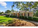 Brick ranch home with manicured shrubs, black shutters and a welcoming lamp post at 315 Burke Cir, Mcdonough, GA 30253