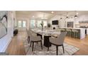 Spacious staged dining area open to the kitchen and living room with hardwood floors and modern lighting at 1947 Clark Dr, Tucker, GA 30084