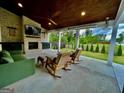 Inviting covered patio with brick fireplace, ceiling fans, comfortable seating, and views of the fenced backyard at 247 Widener Way, Peachtree City, GA 30269