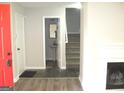 Bright foyer featuring wood-look floors, a red front door, and stairs leading to the upper level at 4383 Chestnut Lake Ave, Lithonia, GA 30038