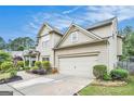 Home featuring a two-car garage with an extended driveway and manicured landscaping at 230 Haleys Ct, Woodstock, GA 30188
