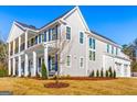 Exterior showing an ample sized lawn, front porch, attached garage, and gray siding at 915 Laurel Brooke Ave, Peachtree City, GA 30269