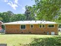 Spacious backyard showcasing a brick home with multiple windows and a lush green lawn at 3548 Meadowview Ct, Rex, GA 30273