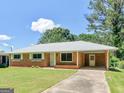 Traditional brick home with a well-kept lawn, inviting entryway, and convenient covered carport at 3548 Meadowview Ct, Rex, GA 30273