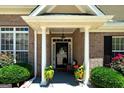 Welcoming front porch with decorative columns, potted plants, and cozy seating area at 127 Laurel Springs Dr, Mcdonough, GA 30253