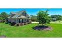 Landscaped yard featuring a mature tree in a mulch bed and green grass at 127 Laurel Springs Dr, Mcdonough, GA 30253