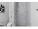 This modern bathroom showcases a tiled shower with new fixtures and pebble flooring at 389 Oglesby Bridge, Conyers, GA 30094