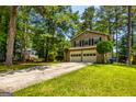 Charming two-story home with a two-car garage surrounded by lush greenery and mature trees at 6500 Wild Turkey Trl, Riverdale, GA 30296
