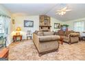 Cozy living room with stone fireplace, comfortable seating, and bright natural light at 6500 Wild Turkey Trl, Riverdale, GA 30296