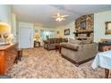 Comfortable living room features a stone fireplace, plush furnishings, and ample natural light from the windows at 6500 Wild Turkey Trl, Riverdale, GA 30296