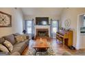 Bright living room featuring a fireplace, piano, hardwood floors, and large windows at 50 Berkshire Pass, Covington, GA 30016