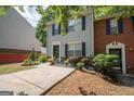 Attractive townhome showcasing a neatly landscaped yard, mature bushes and a concrete driveway at 1346 Revelstoke Cv, Riverdale, GA 30296