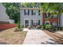 Inviting townhome with a well-kept lawn, complemented by decorative plants and a concrete driveway at 1346 Revelstoke Cv, Riverdale, GA 30296